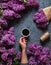 Coffee mug with bouquet of flowers spring lilac branches blossoming in the month of May on grey background view from