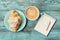 Coffee mug with croissant and empty notebook and pencil for business plan and design ideas on turquoise rustic table from above