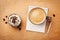 Coffee mug with cupcake, notebook and pencil on rustic table from above, good morning or have a nice day concept