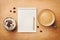 Coffee mug with cupcake, notebook and pencil on rustic table from above, good morning or have a nice day concept