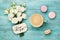 Coffee mug with macaron, white flowers and notes good morning on blue rustic table from above. Beautiful breakfast. Flat lay.
