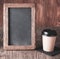 Coffee paper cup with vintage slate chalk board, on grunge wood table