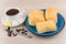 Coffee, pieces of lemon and sugar, plate with flaky biscuits