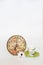 Coffee pot on a green saucer, decorative patterned clock and white daisy flower on a white background