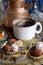 The coffee pot pours the coffee into the cup. in the oriental style. handmade candies, dried fruits and flowers. photo in the