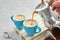 Coffee pouring in  cups from Italian coffee espresso maker. Two coffee mugs and moka coffee pot