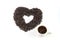 Coffee seeds arrange is heart and white cup of coffee