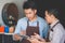 Coffee shop owner discussing with his employee using tablet