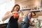 Coffee shop workers young smiling man and woman making coffee with machine, professional baristas team cafe business