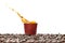 Coffee splash in brown disposable paper cup with coffee beans isolated on white.