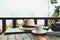 Coffee, straw hat, camera and laptop on the table at resort and beach background