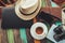 Coffee, straw hat, camera and laptop on the table at resort and beach background