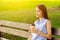 Coffee take away,teenager girl with a glass of invigorating black drink in the morning on a bench in nature