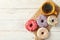 Coffee and tasty donuts on wooden background,  top view