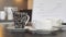 Coffee and tea cups on a sideboard in front of a blurred flip chart with business graphics