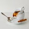 Coffee or tea spilling out of porcelain cup on white background. Square image.