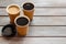 Coffee to take away in paper cups with lids on wooden table background space for text