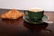 Coffee in vintage cafe cup and croissant on wood ancient table