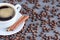 Coffee in white cup with coffee beans and cinnamon