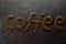 Coffee word lined with coffee beans on a dark background