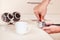 Coffeemaker hands making coffee tablet in holder with tamper on table