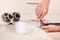 Coffeemaker hands presses coffee tablet in holder with tamper on table