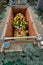 Coffin with bouqet of flowers in a grave