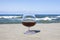 Cognac glass on the background of the sea horizon. Whiskey in a glass on the beach, alcohol and relaxation