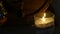 Cognac glass at the candlelight with wooden barrels in romantic evening. slow motion