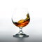 Cognac glass with splashing brandy inside