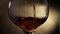 Cognac is rotated in a glass. On dark background.