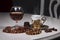 Cognac in tulip-shaped glass, amber jewelry and golden coffee cup on table