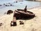 Cogwheel of old ship stranded on beach with plastic bottle garbage