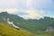 Cogwheel trains climbing up at to Brienzer Rothorn mountain, through the green valley. view to lake Brienzersee