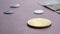 The coin bitcoin lies on a pink background in sharpness, and behind it lie ordinary traditional coins in blur
