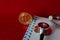 Coin bitcoin, notebook,stethoscope and a magnifying glass isolated on red background