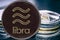 Coin cryptocurrency Libra on the background of a stack of coins.