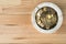 Coin money in marble ashtray on natural wooden background