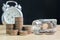 Coin stack with blurred clock and jar background, Finance and in