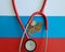 Coin stethoscope and Russian flag closeup. Problem of treatment in Russian Federation