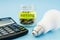 Coins in a bank, LED light bulb and calculator on a blue background. Energy saving concept.