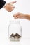 Coins in clear bottle over white background