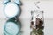 Coins falling into a jar on blurred alarm clock background