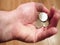 Coins falling into a male hand.