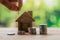 Coins placed on the wood. hand that is coin down the house Indicates the growth of home and finance.