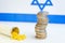 Coins stacked on each other in different positions on colored background. Israeli economy. Pharmaceutical industry in Israel