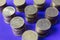 Coins stand on pillars on a background of violets.