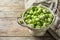 Colander with Brussels sprouts and cloth on wooden background.