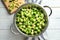 Colander with Brussels sprouts and napkin on wooden background