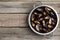 Colander with delicious cooked mussels on wooden table, top view. Space for text
